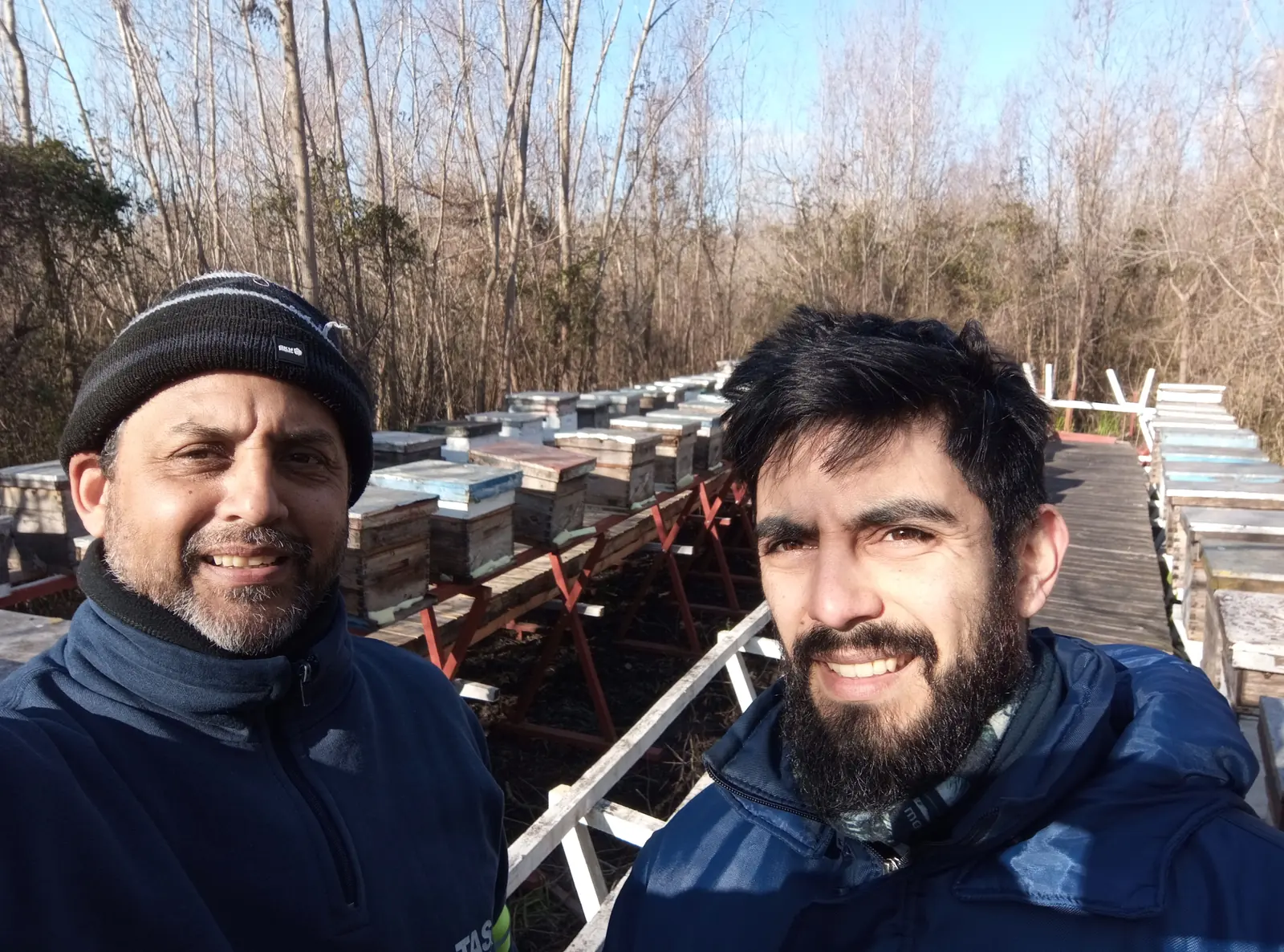 Dos integrantes de Almas del Delta junto a las colmenas